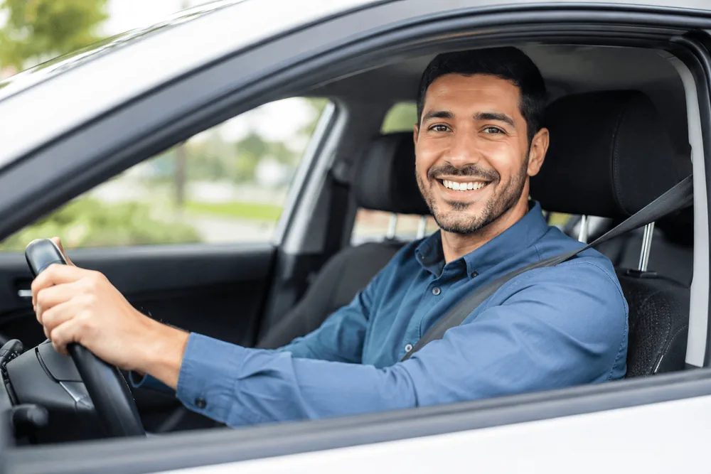 Conducteur souriant au volant